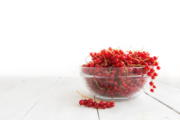 Fresh red currant on the light wooden background