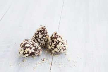Chocolate truffles on white wooden background
