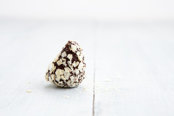 Chocolate truffle on white wooden background