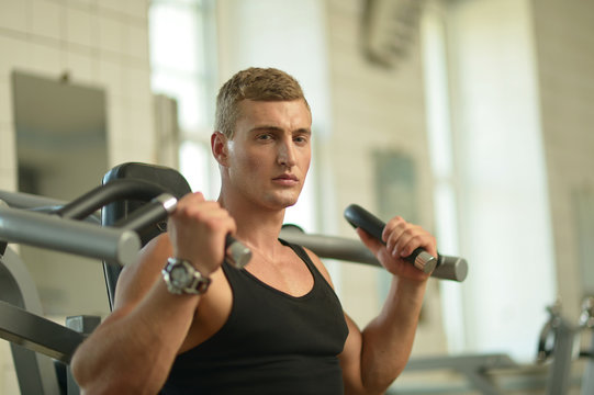 Young man exercises in gym