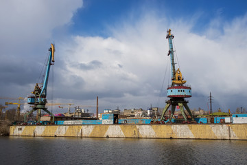 Two old crane loading cargo in the river port