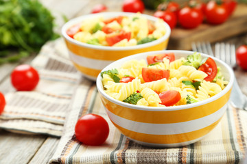 Delicious pasta in bowl on grey wooden background