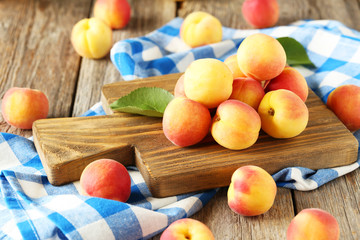 Fresh apricots on cutting board on a grey wooden background