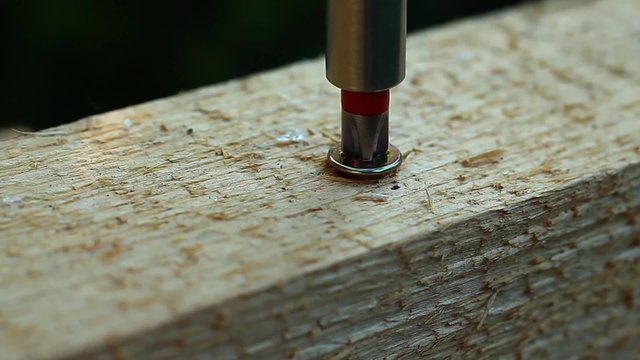 A screw will be screwed into a piece of wood