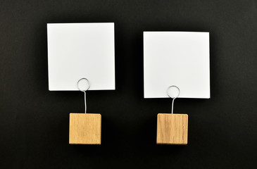 Two paper notes with holders on black background presentation