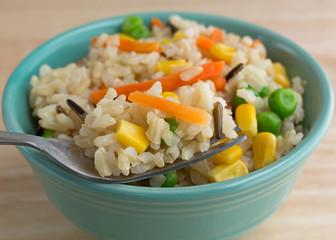Wild and brown rice with veggies in bowl with fork