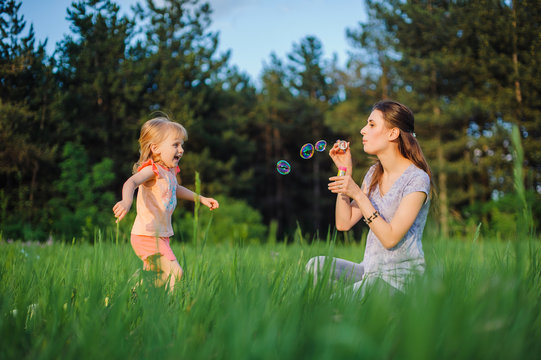 Mom and daughter blow bubbles