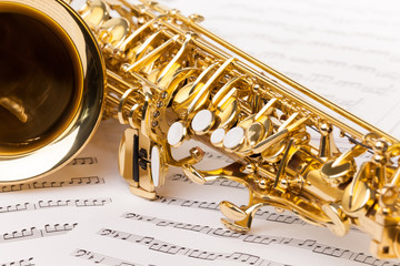 Beautiful golden alto saxophone on musical notes 