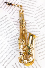 Shiny alto saxophone in full size on musical notes