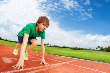Boy in colorful uniform on the start ready to run