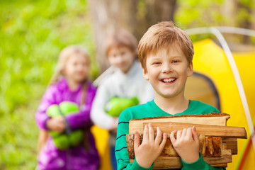 Portrait of happy boy holding the wood for bonfire