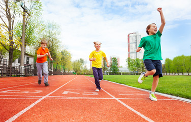 Boys and girl in colorful uniforms run marathon
