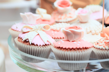 Tasty pink cakes on glass dish