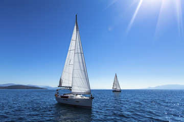 Fototapeta na wymiar Sailing yacht race. Ship yachts with white sails in the open Sea. Luxury boats.