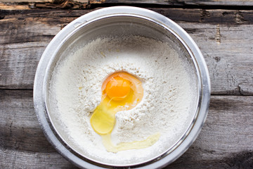 raw egg broken into flour