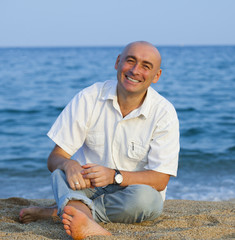  man sitting on  sandy beach