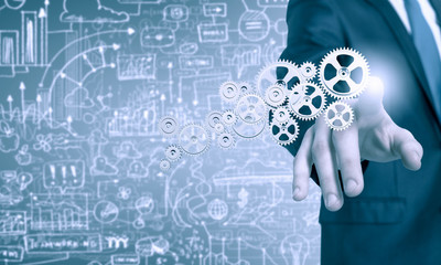 Businessman activating gears mechanism