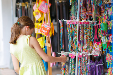 Little girl choosing a necklace at a shop