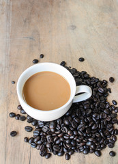 Coffee cup and beans on a wood background