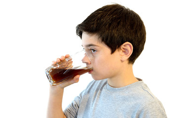 Kid drinking soft drink. Cute caucasian boy drinking from a glass. Isolated on white.