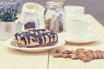 Chocolate cake (eclair) with cup of coffee.  profiteroles with chocolate cream