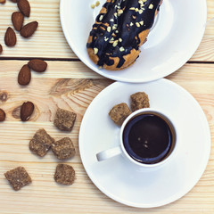 Chocolate cake (eclair) with cup of coffee.  profiteroles with chocolate cream