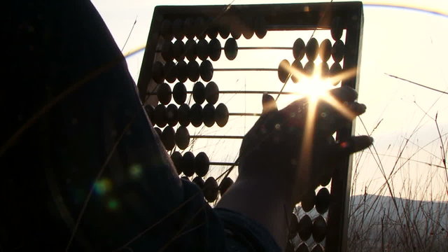 Woman In Black Moving Beads On Abacus At Nature