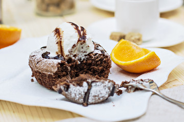 Warm dessert chocolate cake Fondant served on plate with ice-cream ball, almond chips, mint, icing, citron, cacao