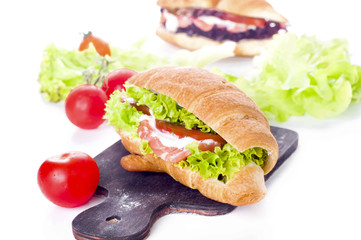 Croissant sandwich with salted salmon on plate,
