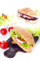 Croissant sandwich with salted salmon on plate,