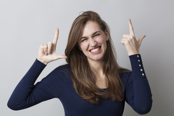 smiling young girl making the LOL sign for abbreviation of laughter and cool smile in hand gesture