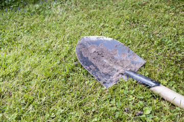 Dirty shovel in grass