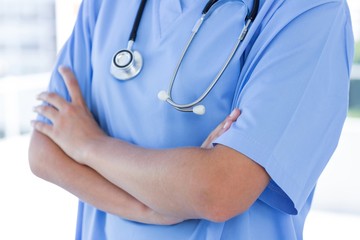 Close-up view of doctor standing with arms crossed 