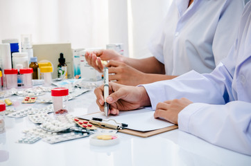 two pharmacists preparing prescription and pill container
