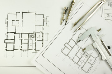 Architectural project, blueprints, blueprint rolls and divider compass, calipers, folding ruler on plans Engineering tools view from the top. Copy space. Construction background.