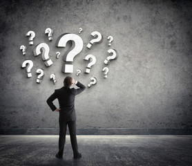 Thoughtful businessman with questions marks
