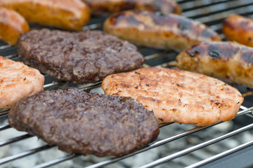 BBQ - Exotic meat burgers and sausages on a lit barbecue (kangaroo, crocodile and wild boar).
