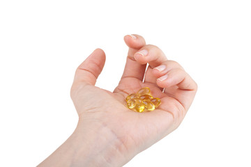 Cod liver oil pills in hand on white