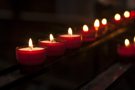 red candles in the darkness of a church