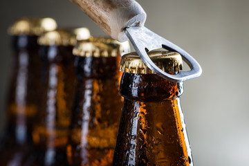 Bruine ijskoude bierflesjes met oude opener