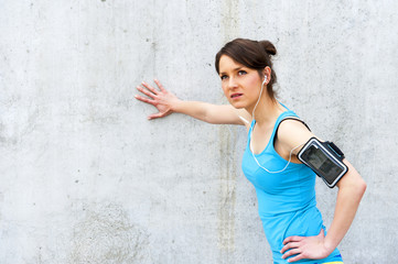 young woman resting after run by the wall in city with big smile