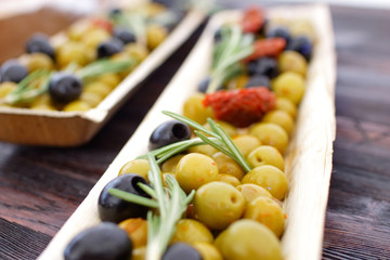 black and green olives, herbs, sun-dried tomatoes in an oblong d