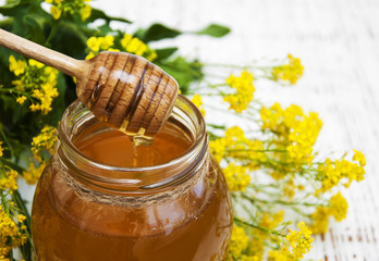 Jar of honey with rape flowers