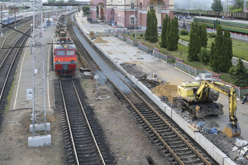 The electric train arrives to the railway station. Repair of roa