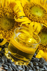 Fresh sunflower oil in a glass with flowers sunflowers and sunfl