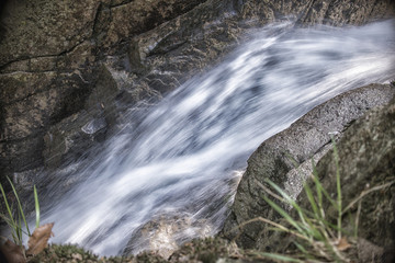 Fototapeta na wymiar Fast flowing water in the mountain river
