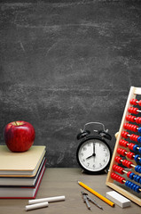 Back To School / School Supplies, an Apple and an Alarm Clock on a Desk in front of a Blackboard