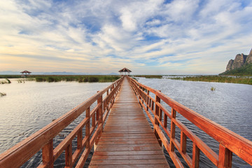 Obraz premium Wooden Bridge in lotus lake on sunset time at Khao Sam Roi Yot National Park, Thailand