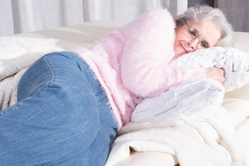 active female senior relaxing on couch