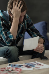 Obraz premium Woeful man looking at pictures